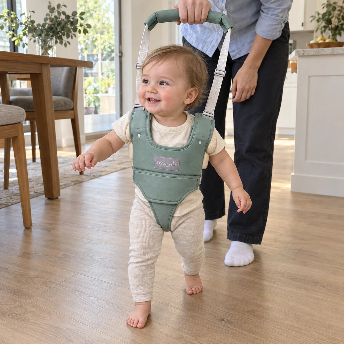 Toddler taking steps across the kitchen floor in the baby walking harness