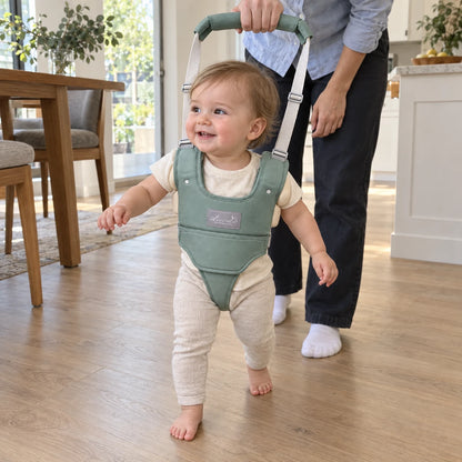 Toddler taking steps across the kitchen floor in the baby walking harness